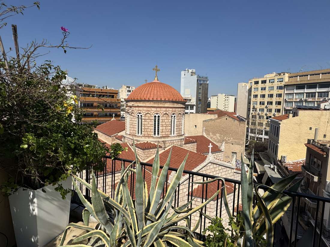 Veranda view of the Chryssopigiotissa church dome among agave plants, Monastiraki, Athens