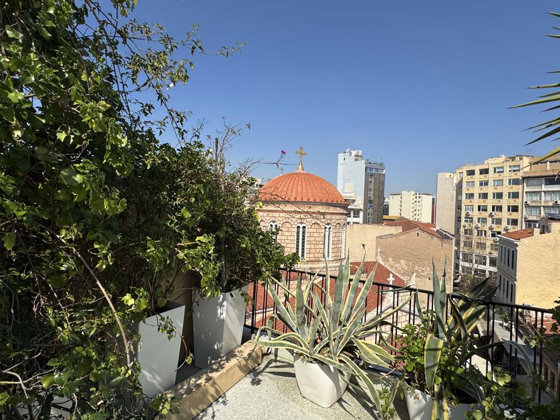 Church dome view from the veranda through greenery, Monastiraki, Athens